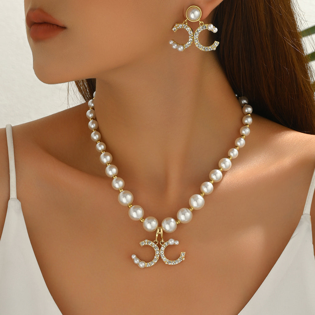 Diamond earrings paired with a long pearl necklace set